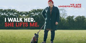 We Are Undefeatable Campaign: "I walk her. She lifts me." Woman walking her dog