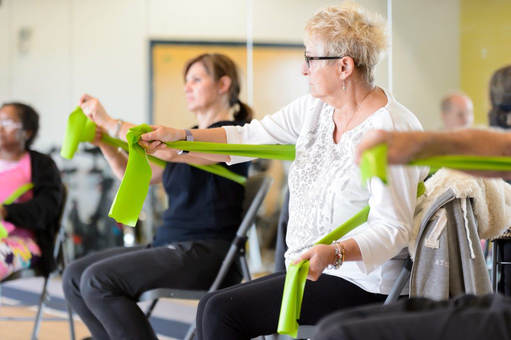 an exercise group doing seated resistance band exercises